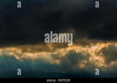 Dramatische Himmel, Licht bricht durch die Gewitterwolken in einem stürmischen Himmel, Schottland, Großbritannien Stockfoto