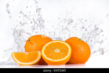 Orangen mit Wasser spritzt auf weißem Hintergrund Stockfoto