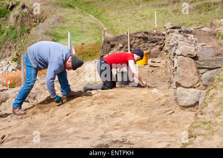 Aushubarbeiten in Whitesands Bay, Pembrokeshire Coast National Park, Wales, Großbritannien im Mai - Mann und Frau mit Kelle Aushub Stockfoto