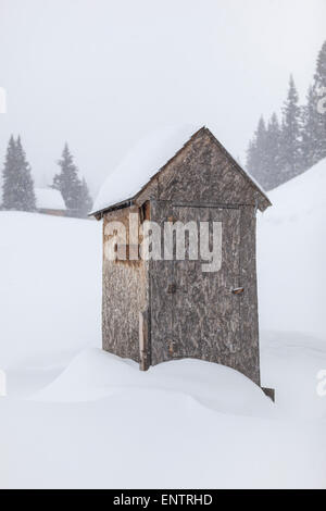 Ein Plumpsklo im Schnee auf einer Backcountry-Hütte über Red Mountain Pass, San Juan National Forest, Colorado begraben. Stockfoto