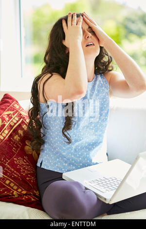 Gestresste Mädchen mit Laptop online Stockfoto