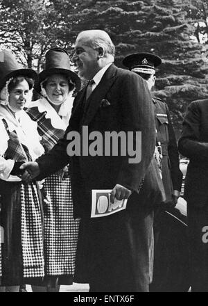 Nach Hause Sekretär David Maxwell Fyffe grüßt eine Frau in Tracht auf der walisische industrielle Messe in Cardiff. 10. September 1952. Stockfoto