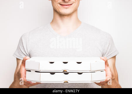 Pizzamann in graues T-shirt hält zwei Kisten mit Lebensmitteln. Stockfoto