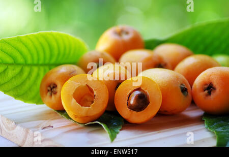 Loquat Mispel Frucht isoliert auf einem grünen Hintergrund Stockfoto