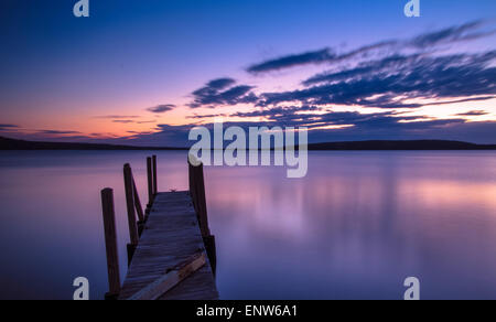 Lake Superior Sonnenaufgang. Sonnenaufgang über dem Lake Superior Horizont mit einem Dock in den Vordergrund und Grand Island im Hintergrund. Stockfoto