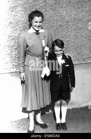 50er Jahre, Religion, Christentum, Erstkommunion, Kinder Kommunion, Kommunion Kind mit Kommunion Kerze und Prayerbook, Boy, 8 bis 10 Jahre, posiert mit Schwester in einem Faltenrock, 16 bis 18 Jahre, Doris, Werner Stockfoto