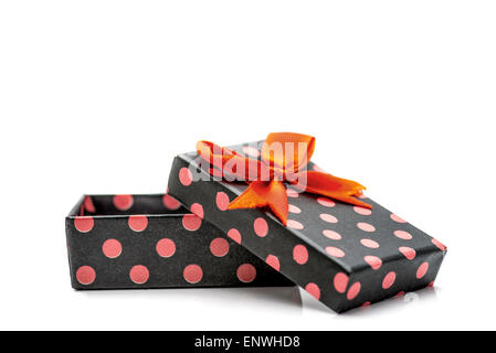 Schwarze Geschenkbox mit rosa Punkten und orange Band in weißen Hintergrund isoliert Stockfoto