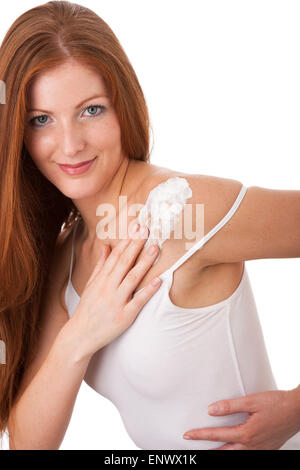 Körper Pflege Serie - lange rote Haare Frau eincremen Stockfoto