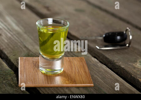 Autoschlüssel mit einem Schnapsgläser über Holz Hintergrund - Getränk Antriebskonzept Stockfoto