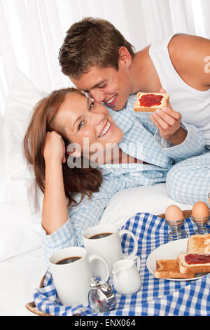 Junges Paar mit nach Hause gemacht Frühstück im Bett Stockfoto