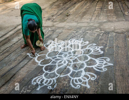 Indische Frau zeichnen ein Kolam vor Ort in Tiruvannamalai, Indien Stockfoto