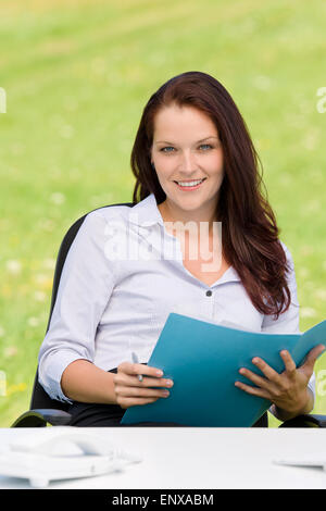 Geschäftsfrau im Ordner "Natur attraktives Lächeln" Stockfoto
