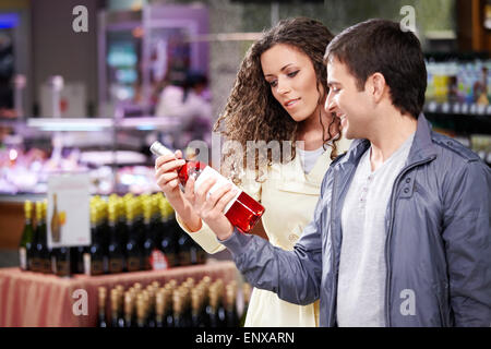 Das junge Paar wählt eine Flasche Weine im shop Stockfoto