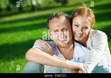 Junges Paar Lachen umfasst im Sommergarten Stockfoto