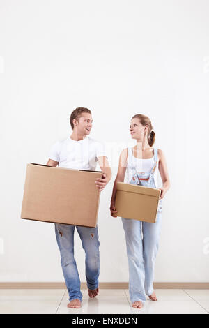Attraktives Paar bewegt sich Kartons im neuen Zuhause Stockfoto