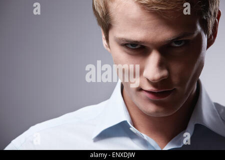 Porträt eines jungen attraktiven Mannes mit einem grauen Hintergrund Stockfoto