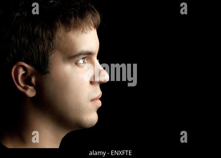 Closeup Portrait des jungen Mannes isoliert auf schwarz Stockfoto