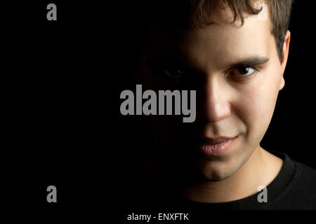 Closeup Portrait des jungen Mannes isoliert auf schwarz Stockfoto