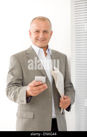 Geschäftsmann lächelnd Reifen halten Telefon Porträt Stockfoto