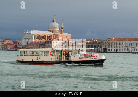 Venedig, Wasserbus oder Vaporetto in der Nähe von Palanca auf den Canale della Giudecca mit der Chiesa di Gesuati im Hintergrund. Stockfoto