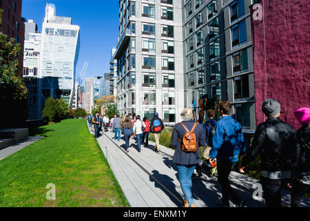 USA, New York, Manhattan, lineare High Line Park zwischen Gebäuden auf einem stillgelegten erhöhte Eisenbahn Sporn mit Menschen auf einem Weg neben der 23rd Street Rasen. Stockfoto