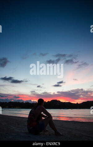Reisenden beobachtet den Sonnenuntergang am Choeng Mon Beach, Koh Samui, Thailand Stockfoto