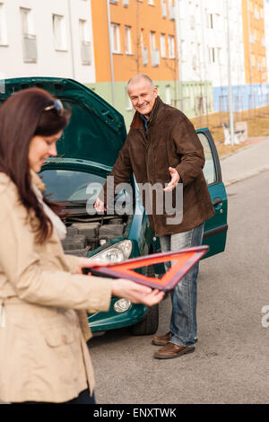 Frau mit Dreieck-Zeichen-Mechaniker Festsetzung Auto Stockfoto