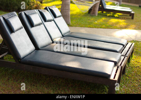 Bett am Pool auf dem Rasen. Stockfoto