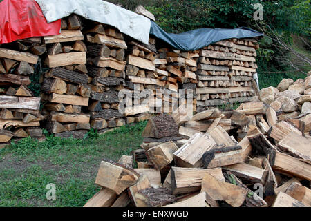 Gehackte Holz in einem großen Haufen und gestapelt in Lagerung Haufen mit lose Beläge an der Spitze Stockfoto