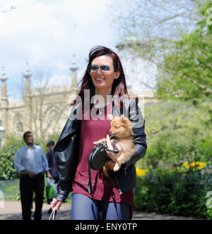 Brighton, UK. 12. Mai 2015. Wetter: Eine junge Frau nimmt ihre kleinen niedlichen Hund für einen Spaziergang in der Sonne durch Brighton Pavilion Gardens heute mit Temperaturen, die hohe Teens erreichen Celsius Credit: Simon Dack/Alamy Live News Stockfoto