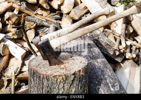 Holzstapel, Deck zum Hacken von Brennholz, Axt und Beil auf rustikalen Innenhof Stockfoto