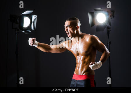 Boxer mit Studioleuchten in Sport-Konzept Stockfoto