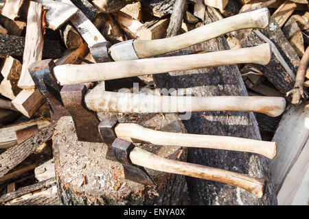 viele verschiedene Achsen in Holz-Block in der Nähe von Stapel Brennhölzer Stockfoto