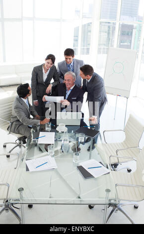 Glücklich vielfältigen Business Leute studieren einen Umsatzbericht Stockfoto