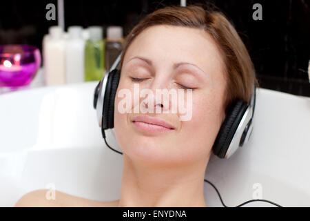Eine junge Frau entspannt Musik hören in einem Schaumbad in Nahaufnahme Stockfoto