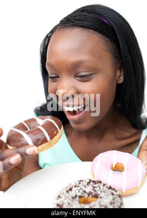 Fröhliche junge Frau Essen einen Schoko donut Stockfoto