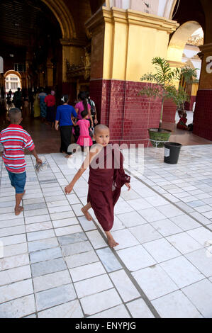 Ein junge Novizin buddhistischer Mönch führt durch einen Tempel in Mandalay Myanmar Stockfoto