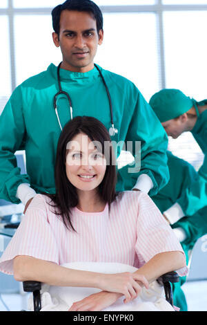 Ethnische Chirurg mit einer Patientin auf einen Rollstuhl Stockfoto