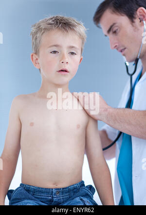 Arzt, die ein Kind mit Stethoskop hören Stockfoto