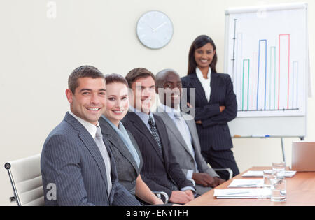 Geschäftsfrau, die Berichterstattung an Verkaufszahlen zu ihren Kollegen in einem meeting Stockfoto