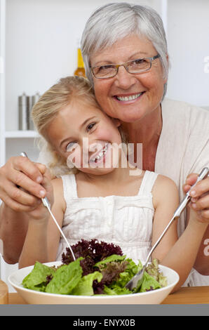 Glückliche Großmutter Essen einen Salat mit Enkelin Stockfoto