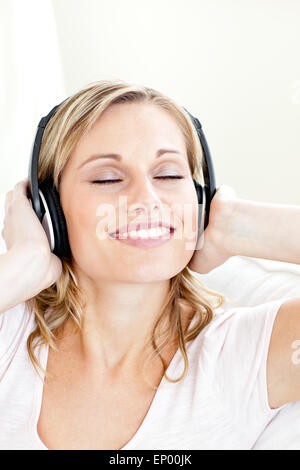 Strahlende junge Frau mit Kopfhörern Musik hören Stockfoto