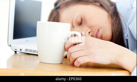 Slumbery Frau schläft auf Tisch im Büro Stockfoto