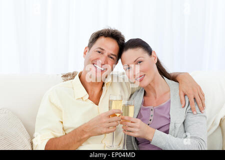 Porträt von ein paar Holding Flöten Champagner auf dem sofa Stockfoto