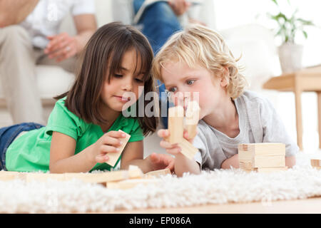 Kleine Jungen und Mädchen zusammen mit Dominosteinen spielen Stockfoto