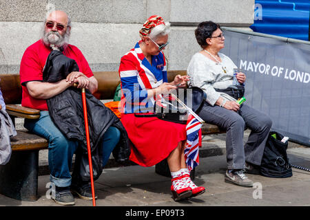 Eine Frau, gekleidet In Anschluß-Markierungsfahne Kostüm sitzen auf dem Trafalgar Square mit einem Smartphone zum 70. Jahrestag des VE Day, London Stockfoto