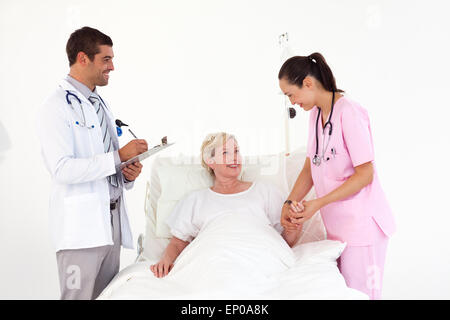 Lächelnder Patient liegt zwischen freundliche Krankenschwester und Arzt Stockfoto