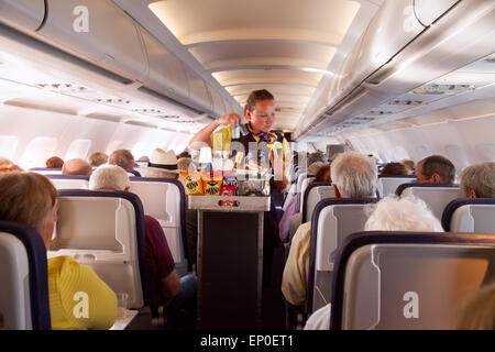 Eine Flugbegleiterin Mitglied des Kabinenpersonals Speisen auf ein Monarch Airlines Flugzeug von Madeira nach Gatwick Flughafen, Vereinigtes Königreich Stockfoto