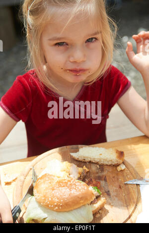 Mädchen essen einen Burger (Hamburger) im restaurant Stockfoto