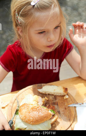 Mädchen essen einen Burger (Hamburger) im restaurant Stockfoto